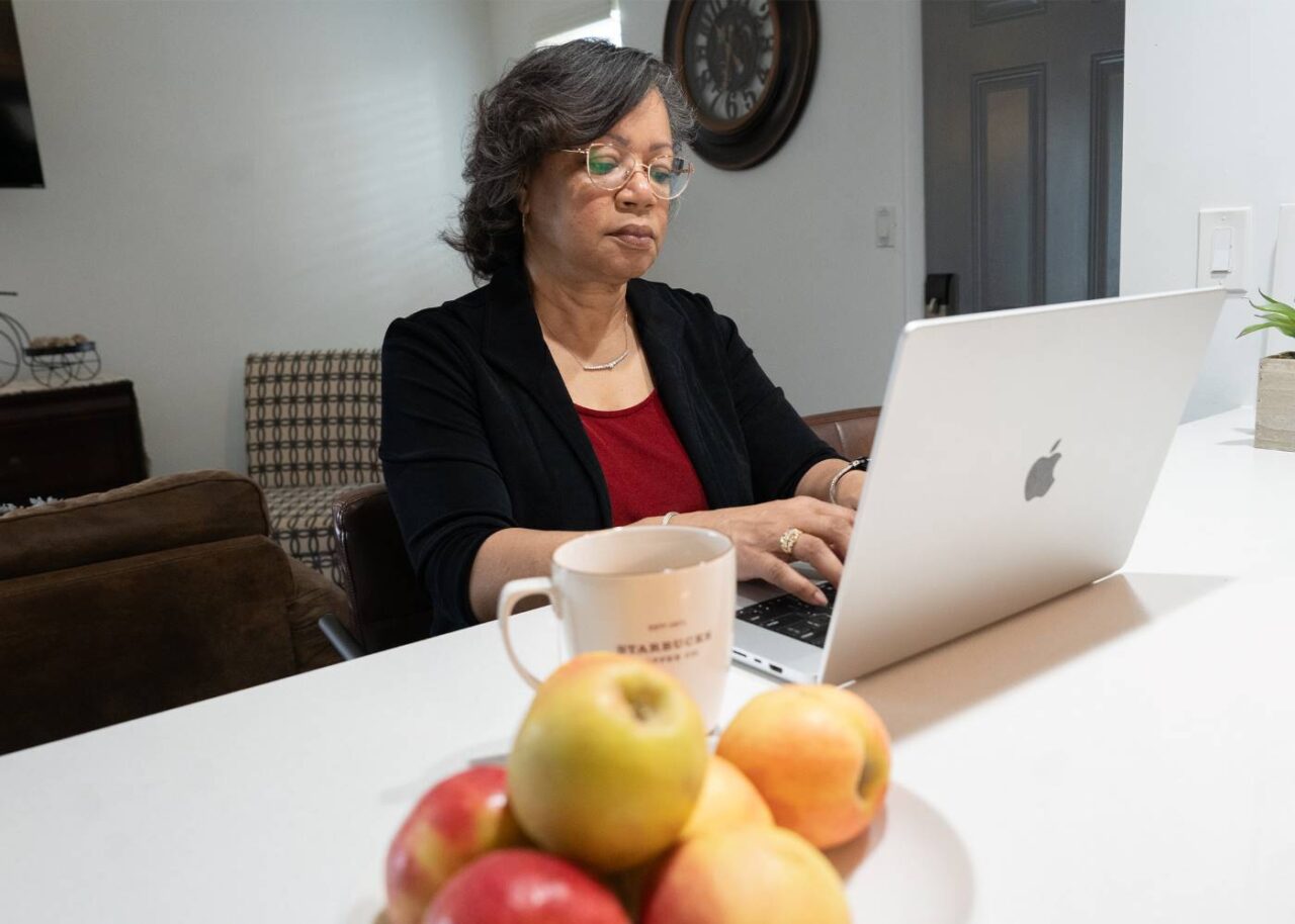 Lisa Roberts, patient of Dr. Whitnee Brown, DNP, CRNP, PMHNP, FNP, on her computer working from home.